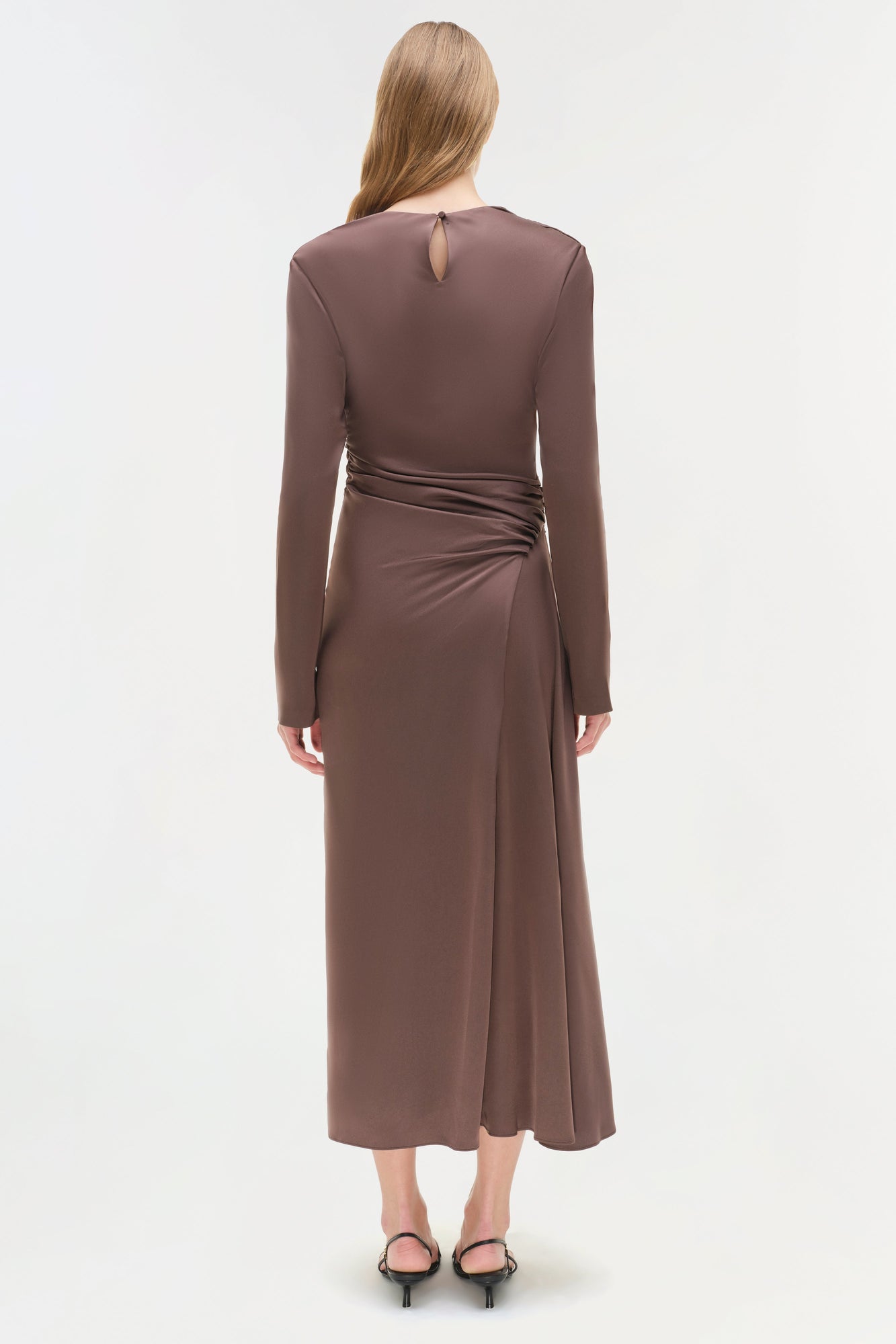 Brown satin midi dress with long sleeves, ruched waist detail, and keyhole back cutout on model.
