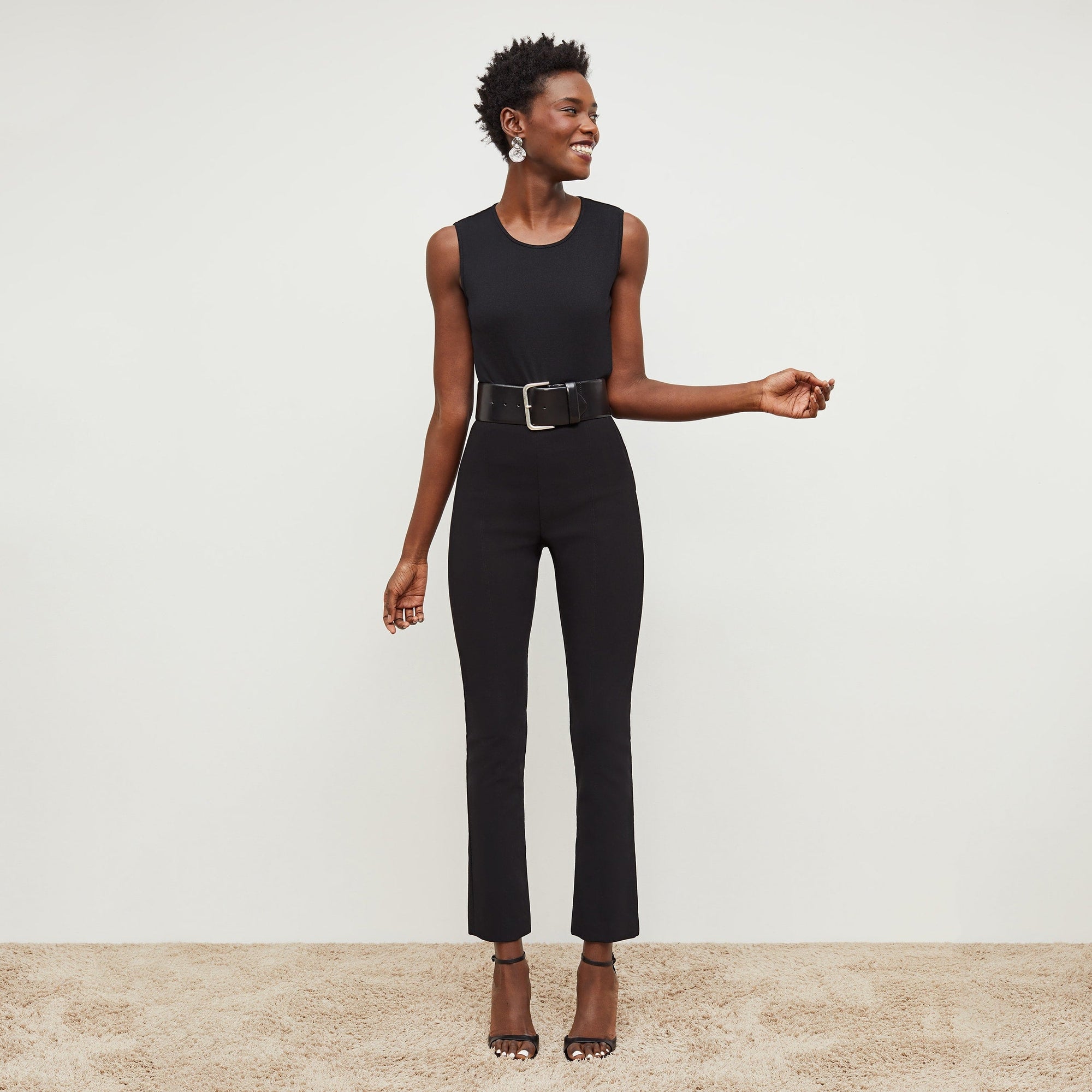 Front image of a woman standing wearing the Foster Pant—Everstretch in Black | Exclude