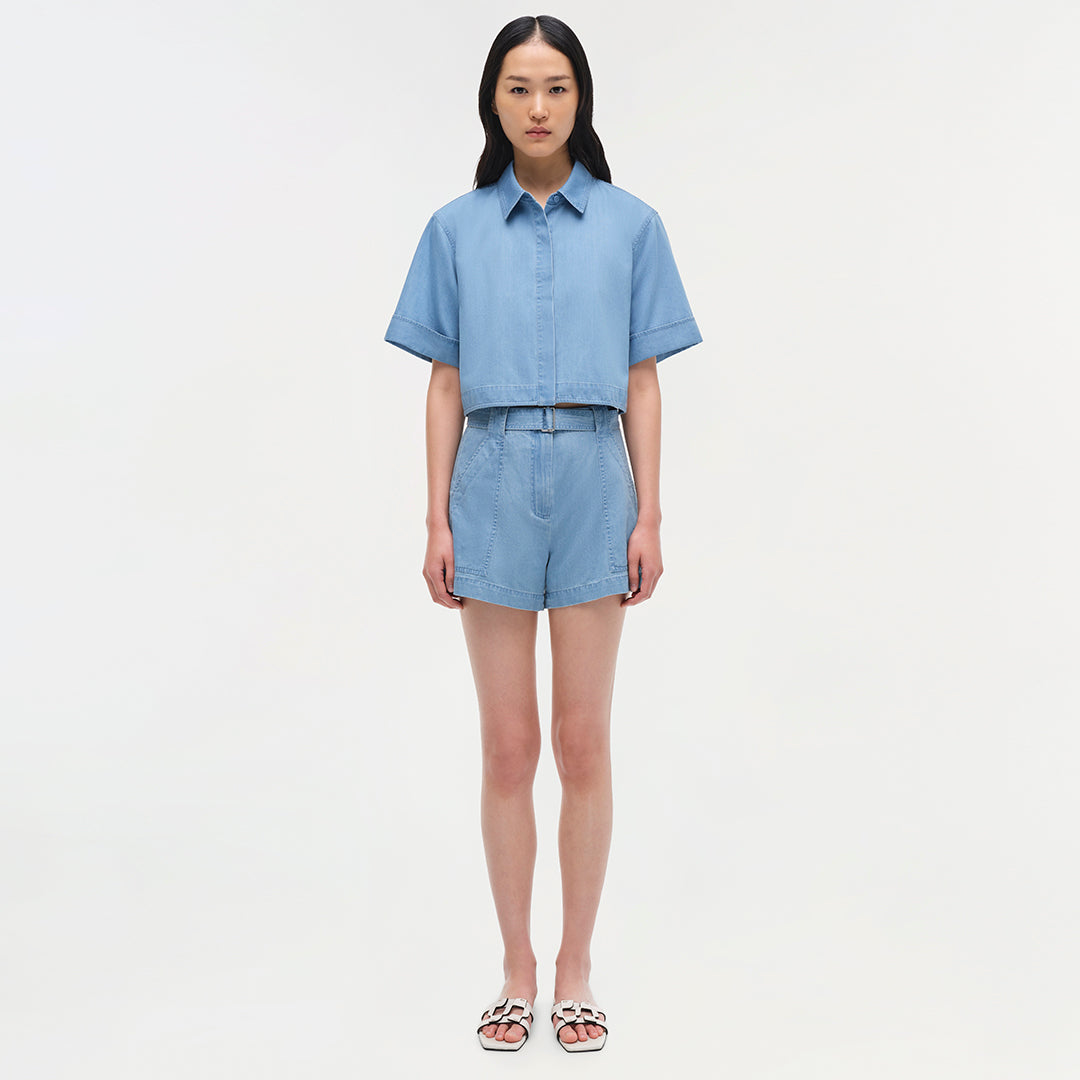 Light blue denim bishop top with short rolled sleeves and collar, worn with matching shorts.
