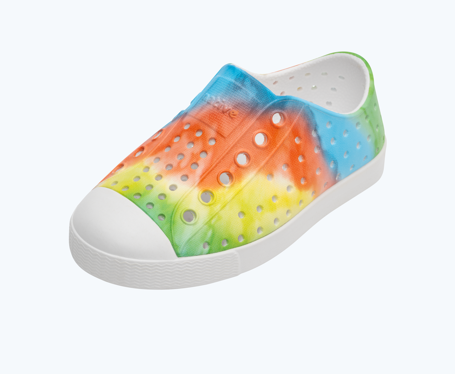 Angled view of a Native Shoes Kids Jefferson Print Kids | Shell White/ Shell White/ Rainbow Tie Dye Footwear