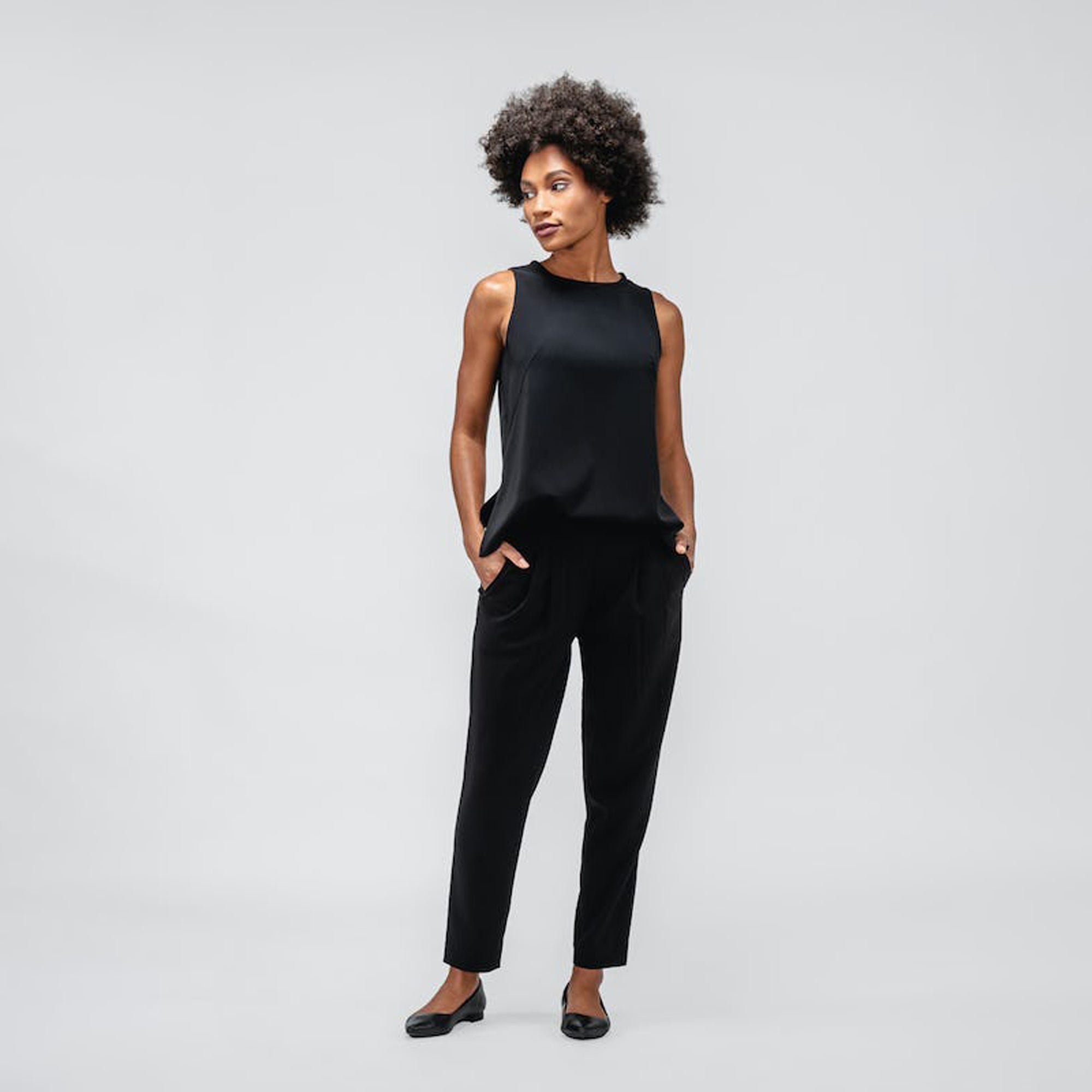 Black Swift Sheath Tank and Swift Drape Pant on model facing forward with hands in pockets