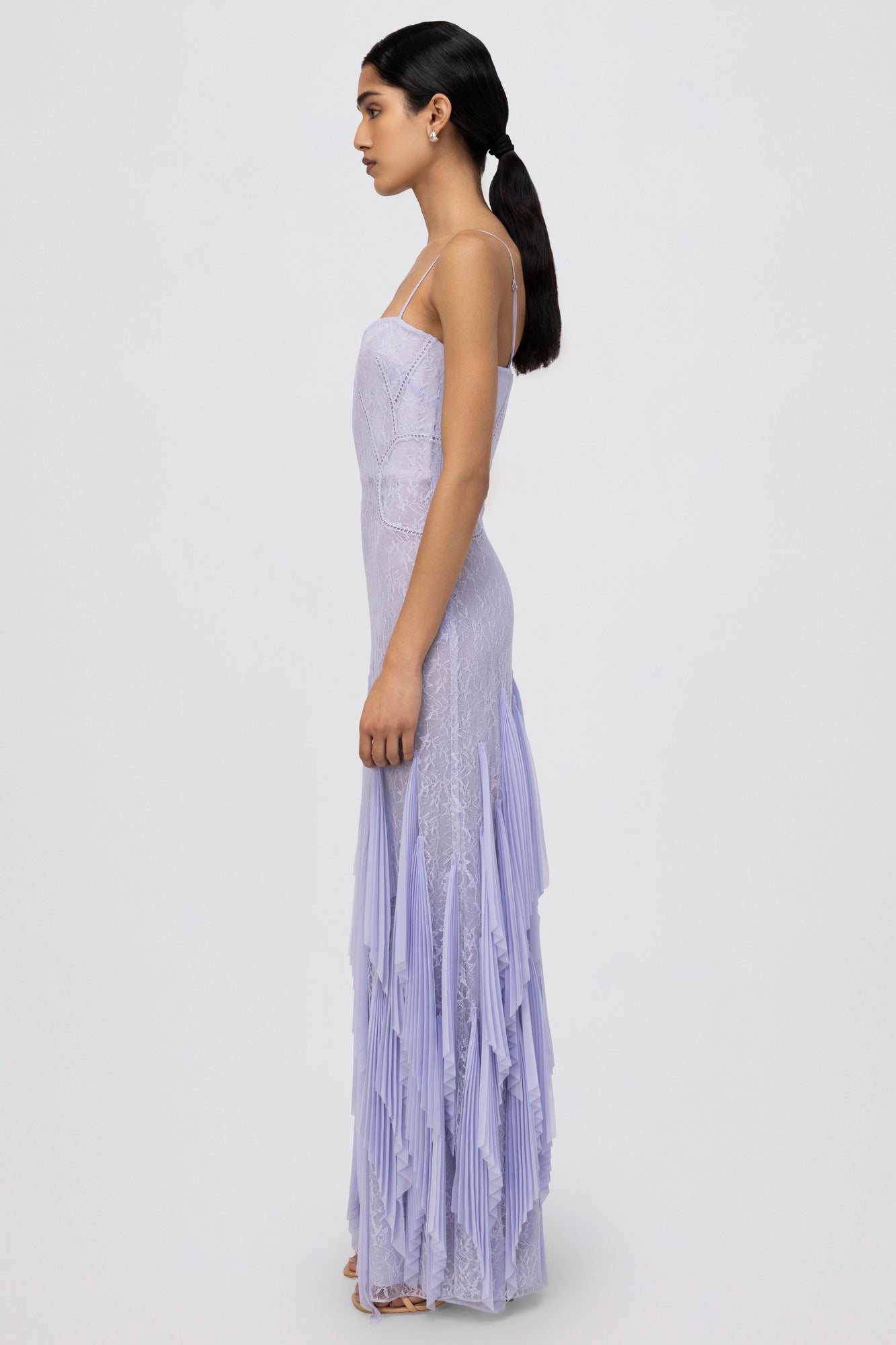 Lavender sleeveless gown with lace bodice, thin straps, and pleated skirt, shown from the side.