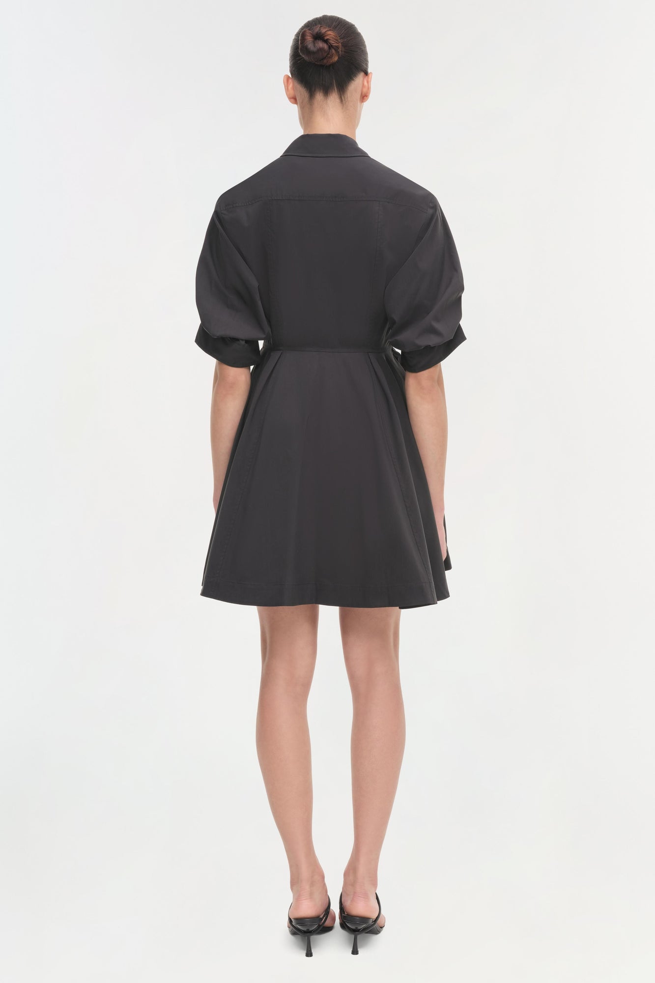 Black shirt dress with rolled short sleeves, belted waist, and A-line skirt, shown from back view.