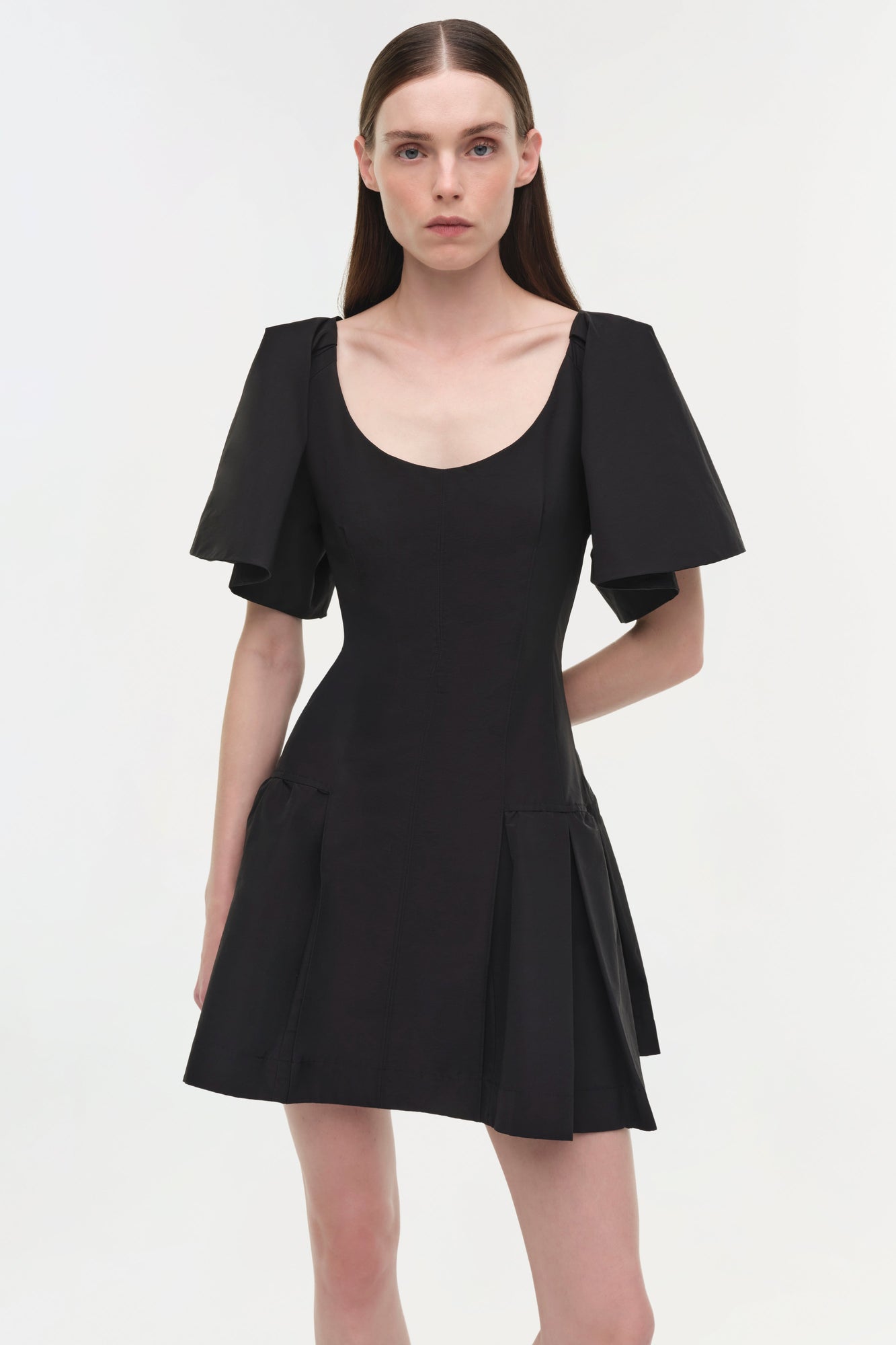 Black cotton faille mini dress with short flutter sleeves, scoop neckline, and pleated skirt detail.