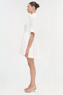 White short-sleeve shirt dress with a-line skirt, shown on model in side profile.