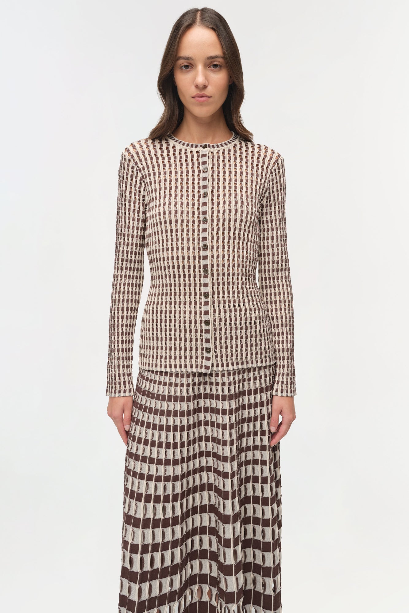 Brown and cream ribbed knit cardigan with button front and geometric patterned skirt.