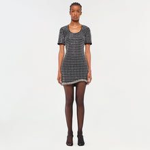 Black and white checked short-sleeve dress with lace trim hem, worn with dark tights and black sandals.