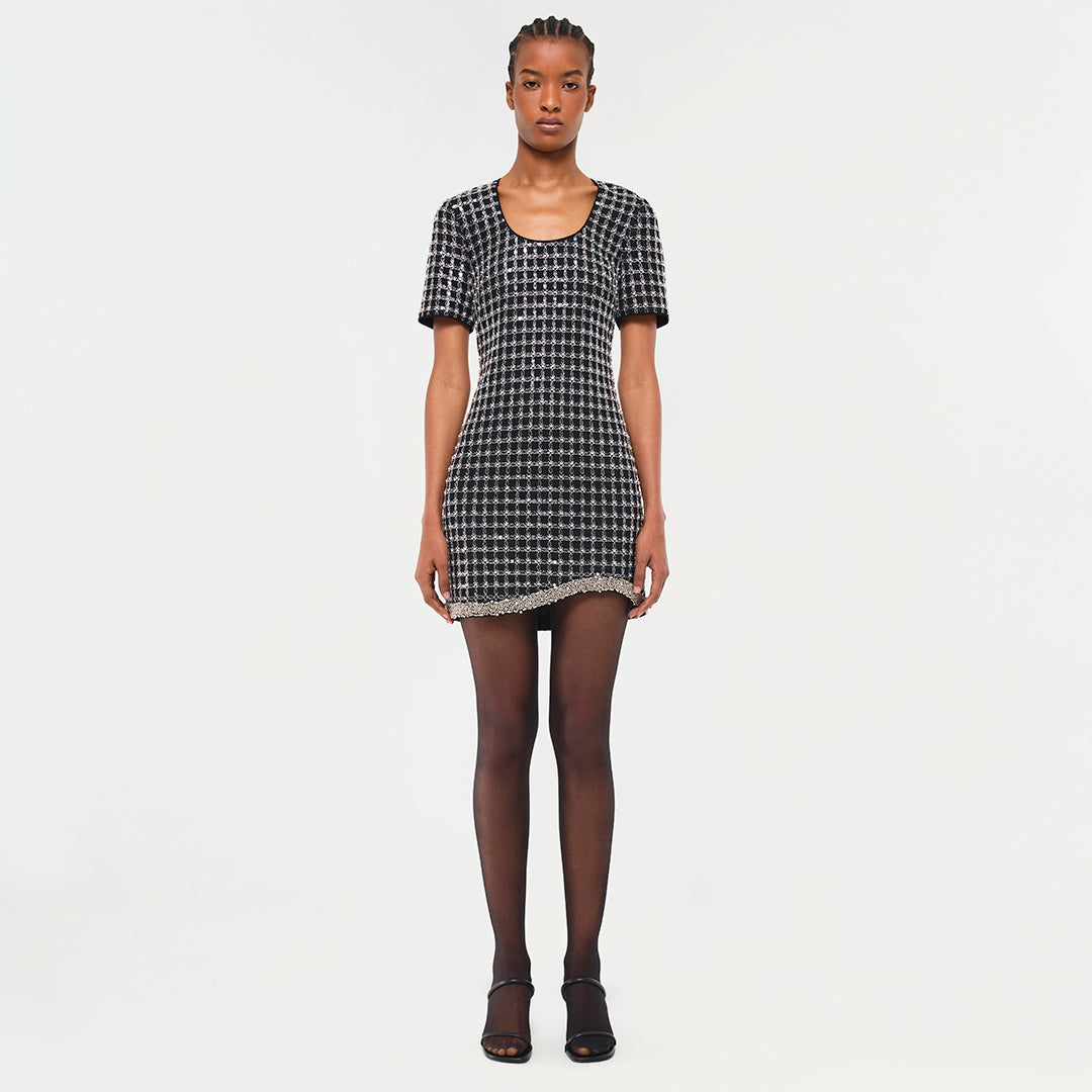 Black and white checked short-sleeve dress with lace trim hem, worn with dark tights and black sandals.
