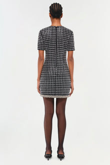 Black and white houndstooth mini dress with short sleeves and beaded hem trim, shown from back.
