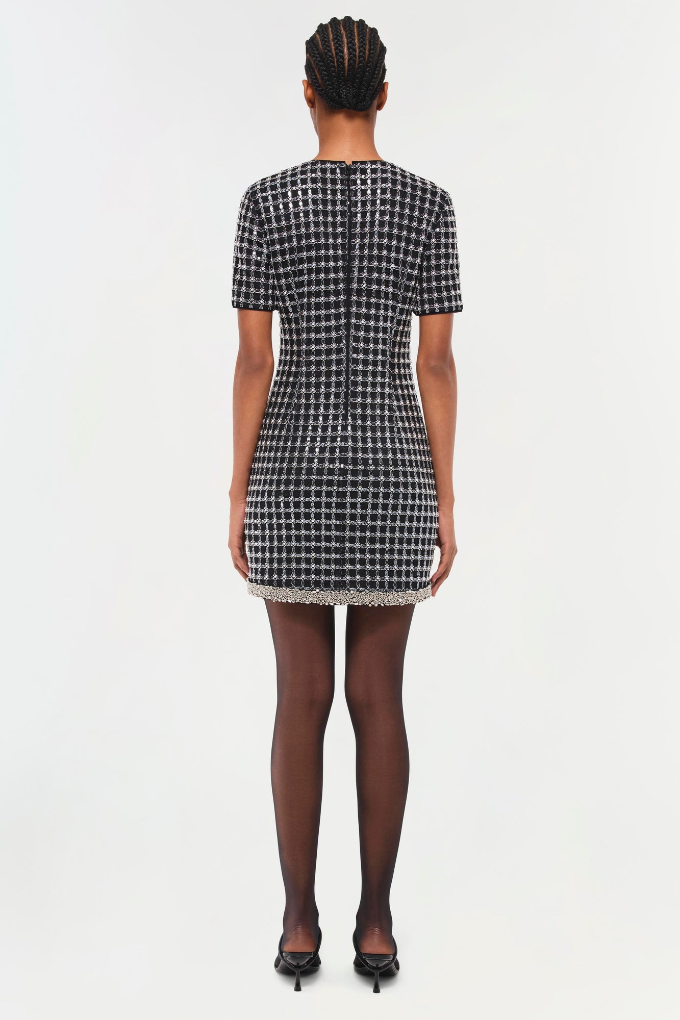 Black and white houndstooth mini dress with short sleeves and beaded hem trim, shown from back.