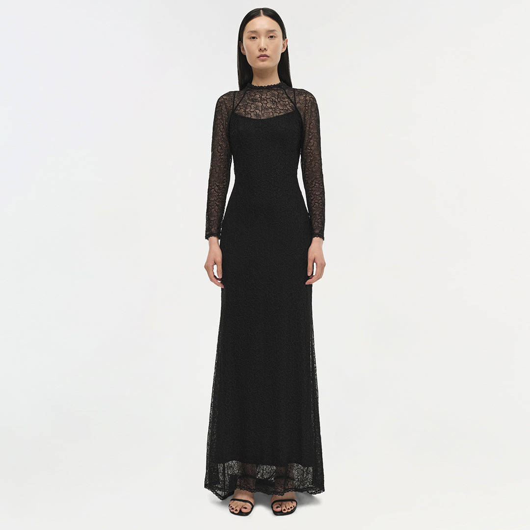 Black long-sleeved lace gown with sheer lace yoke and cuffs, floor-length silhouette.