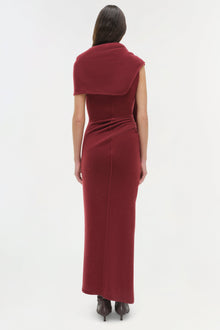Woman wearing burgundy sleeveless midi dress with draped collar detail, viewed from back.