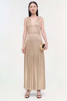 Beige pleated sleeveless gown with deep V-neckline, tiered waist bands, and full-length skirt.
