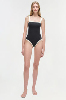 Black and white colorblocked one-piece swimsuit with square neckline and thick shoulder straps.