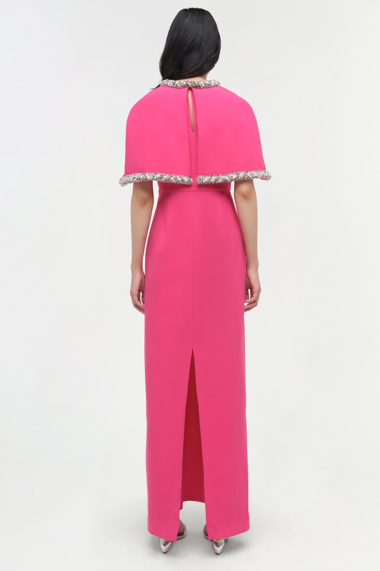 Pink gown with detached cape featuring beaded neckline and hem, back view with center slit.