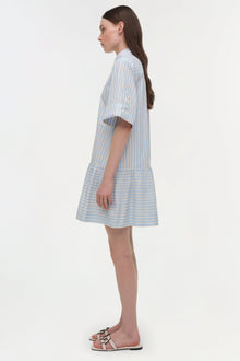 Blue and white striped cotton shirt dress with short sleeves and gathered hem, shown on model in profile view.