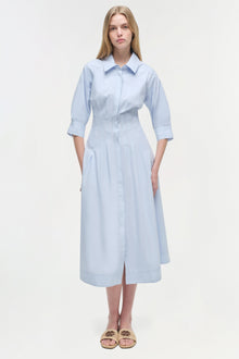Light blue button-front midi dress with three-quarter sleeves, collared neckline, and pleated skirt on model.