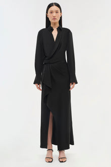 Black wrap dress with long sleeves, collar neckline, and asymmetrical draped skirt with side slit.