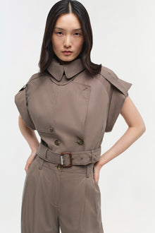 Taupe short-sleeved button-up top with pointed collar, double-breasted buttons, and brown belt at waist.