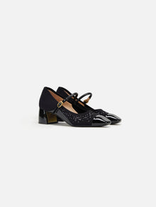 A pair of navy blue, square toe, high-heeled shoes with a buckle strap and a dotted pattern.