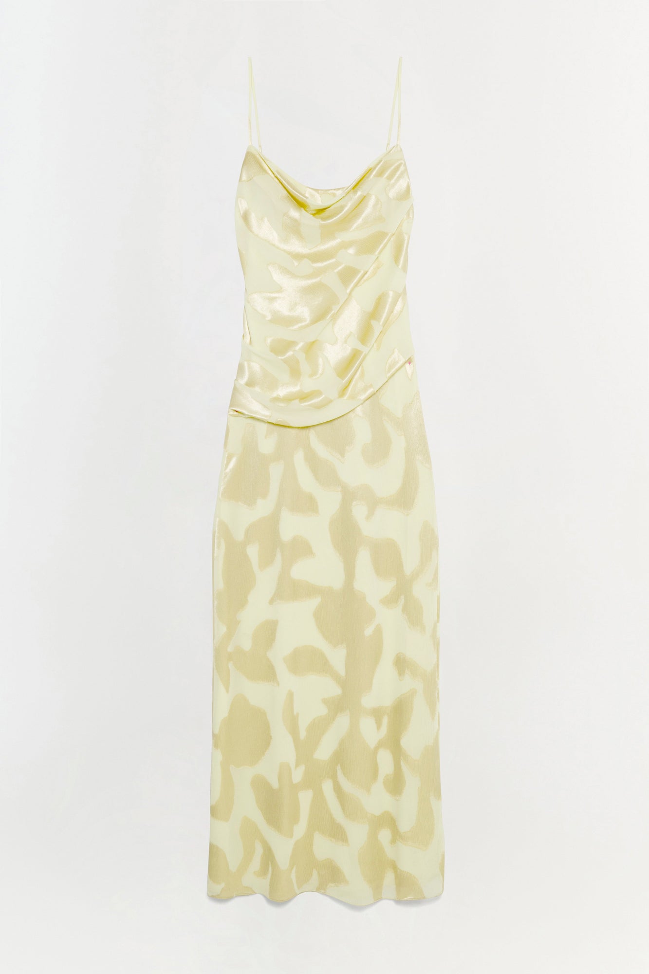 Pale yellow slip gown with cowl neckline, thin straps, and abstract patterned skirt.