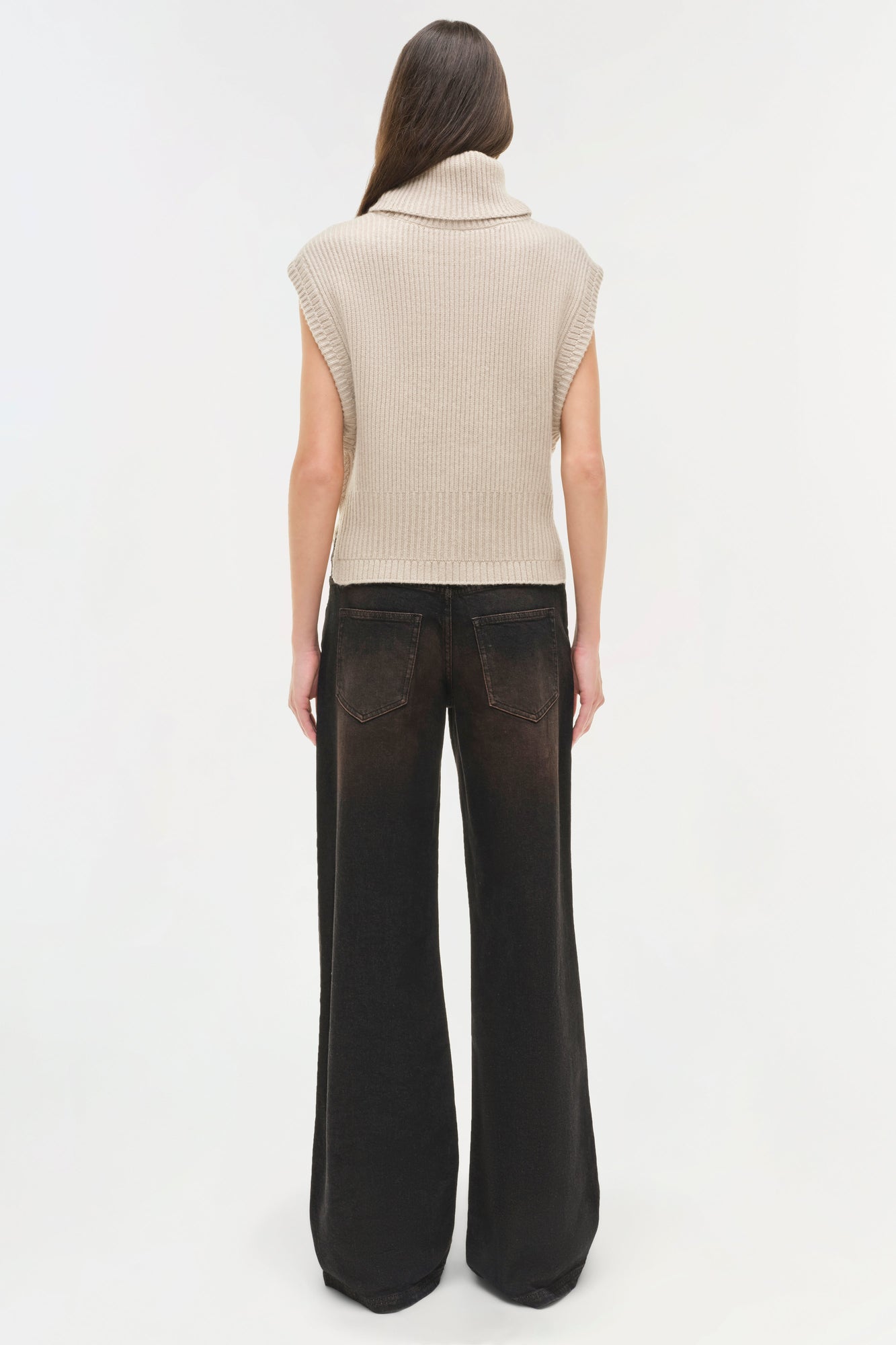 Cream ribbed sleeveless turtleneck top paired with black wide-leg jeans, shown on model from back view.