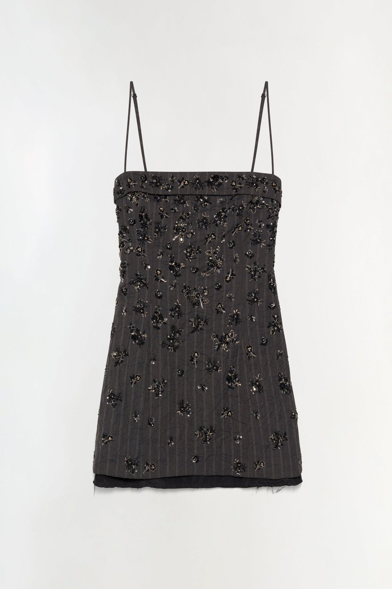 Black mini dress with thin straps and scattered beaded embellishments throughout, featuring a folded neckline and sheer black