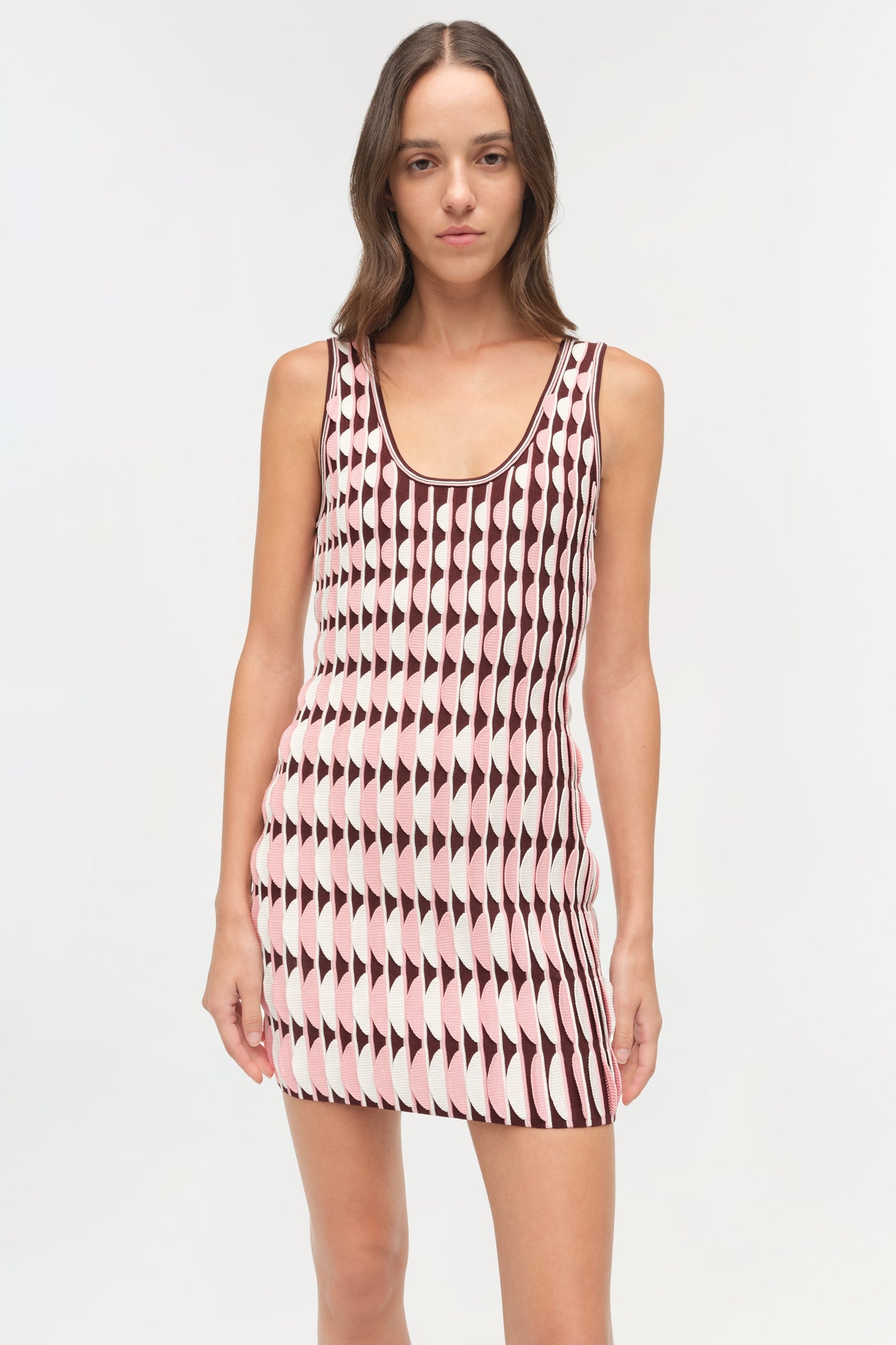 Sleeveless knit mini dress with scalloped geometric pattern in burgundy and pink on cream background.