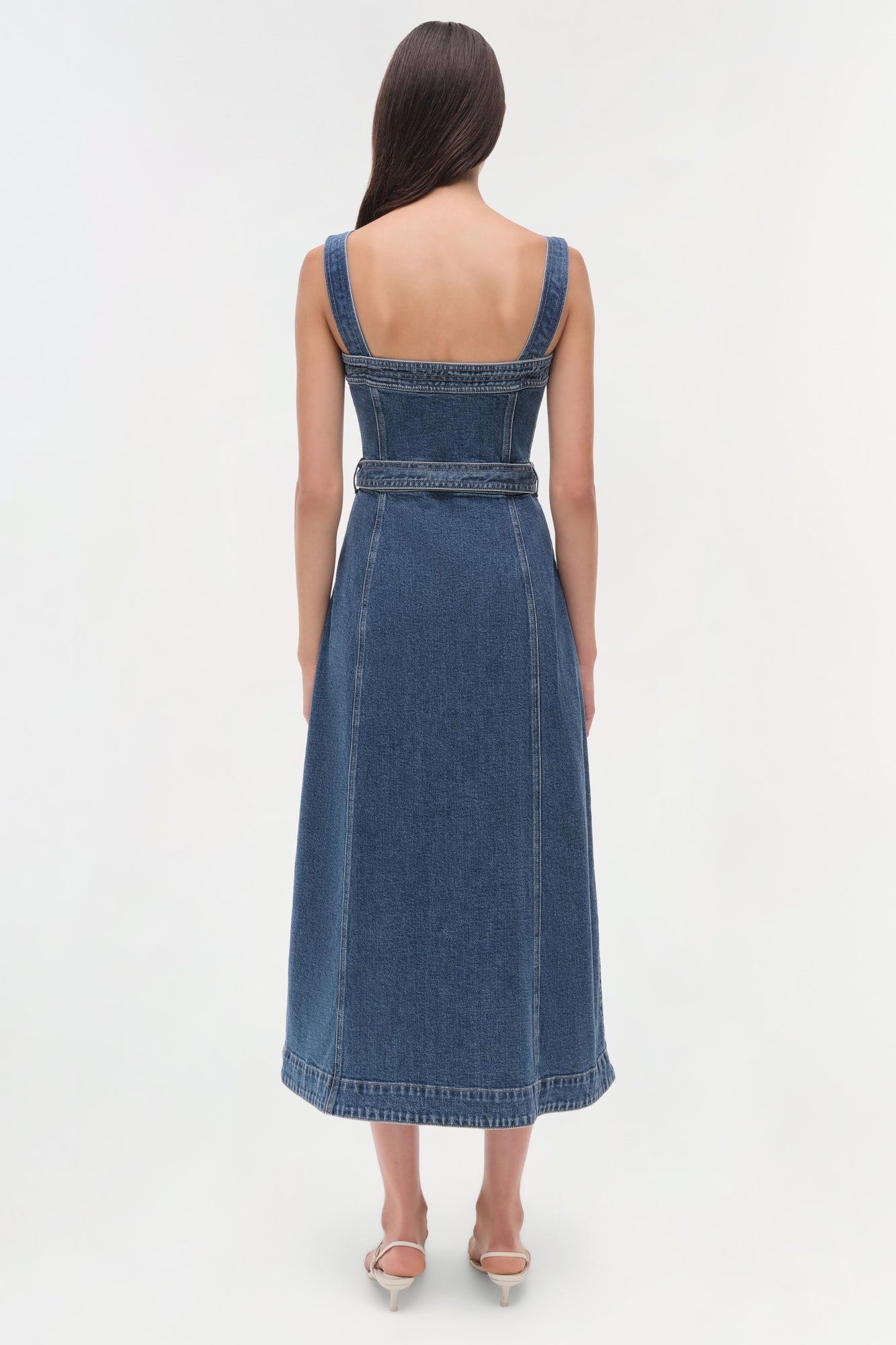 Blue denim sleeveless dress with square neckline, belted waist, and A-line skirt shown from back view.