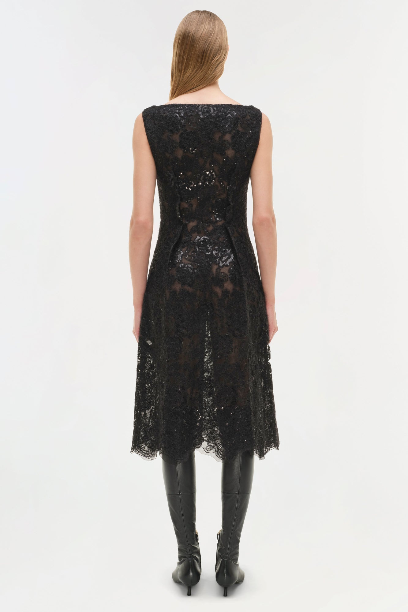 Black sequin lace sleeveless midi dress with irregular hemline, worn with black boots.