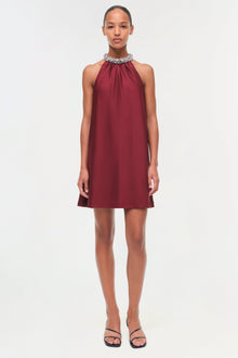 Burgundy satin halter mini dress with jeweled neckline on model wearing black sandals.