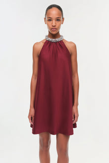 Burgundy halter mini dress with crystal-embellished neckline and flowing A-line silhouette.