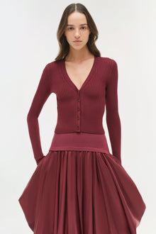 Burgundy midi skirt with gathered taffeta skirt and fitted knit waistband, styled with matching ribbed cardigan.