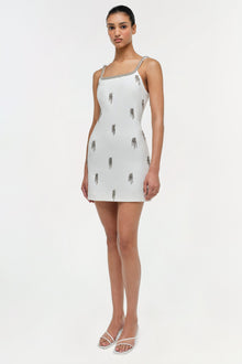 White sleeveless mini dress with silver tassel embellishments and beaded neckline straps.