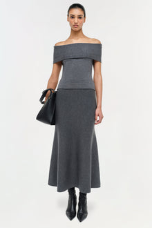 Gray wool A-line skirt with fitted waistband, worn with off-shoulder top and black boots.