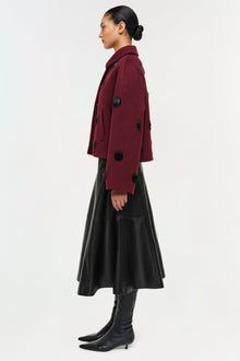 Burgundy wool jacket with black beaded embellishments, worn over black leather skirt and boots.