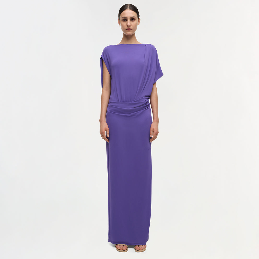 Purple draped gown with short sleeves and ruched waist detail extending to floor length.