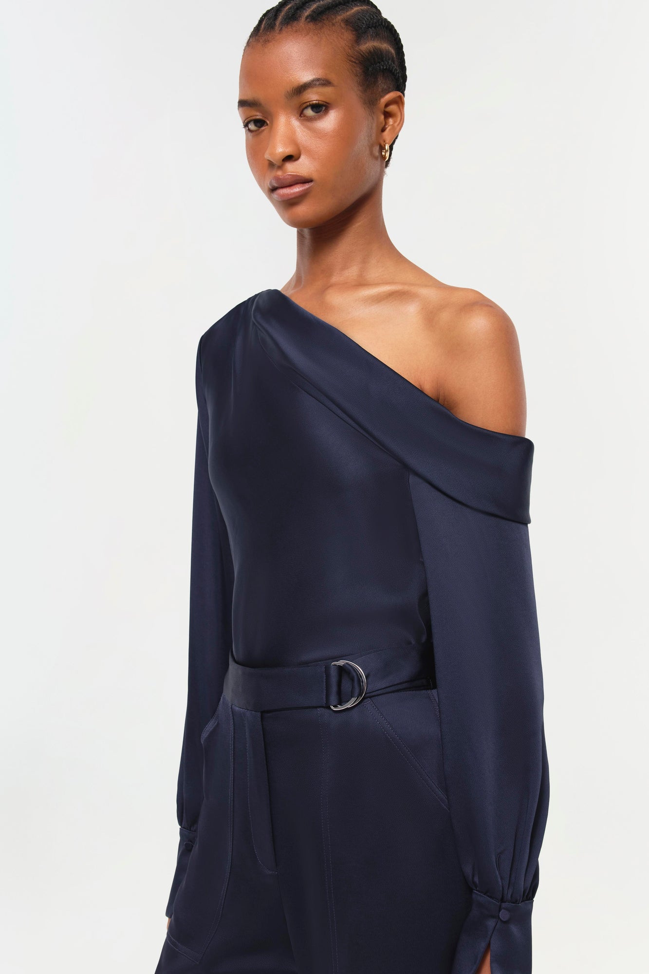 Woman wearing navy Carolina Pant with off-shoulder top and belt detail at waist.
