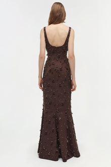 Brown sleeveless gown with beaded embellishments throughout, open back design, worn by model viewed from behind.