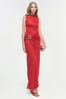 Red sleeveless jersey gown with ruched waist detail and circular ring accent.