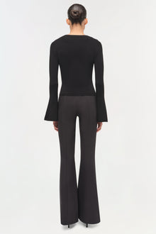 Black wool top with flared long sleeves, shown from back on model wearing black pants.