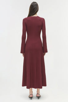 Burgundy ribbed knit midi dress with long sleeves and flared hem, shown on model from back view.