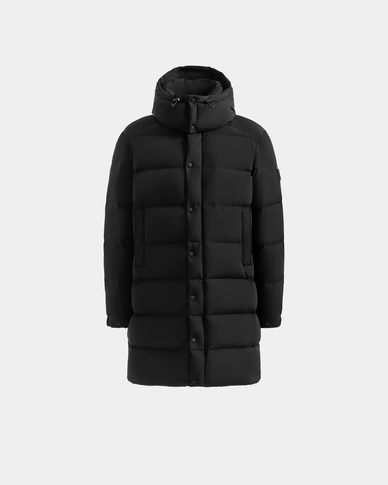 The Rudsak BRAYDEN M-M - M125535 Black is a long men's down puffer coat with a hood, front button closure, and horizontal quilting, shown on a plain light gray background—perfect for versatile winter wear.
