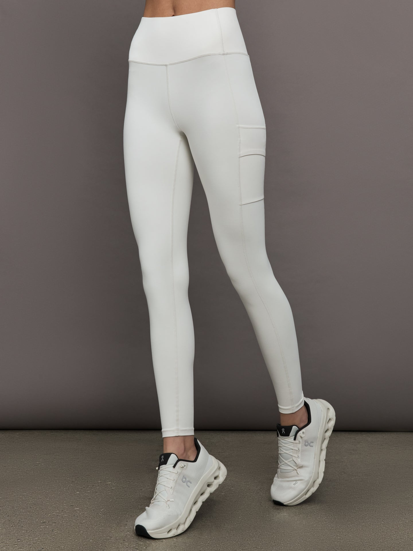 Model wears a highly compressive white high waisted legging with side pocket on outer thigh. 