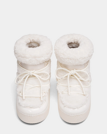 The Rudsak KATHY Y - 1224500 Iceland boots are white, furry winter boots with thick soles, round toes, front laces, and a plush sherpa-like finish. Water-repellent moon boots shown side by side on a white background.
