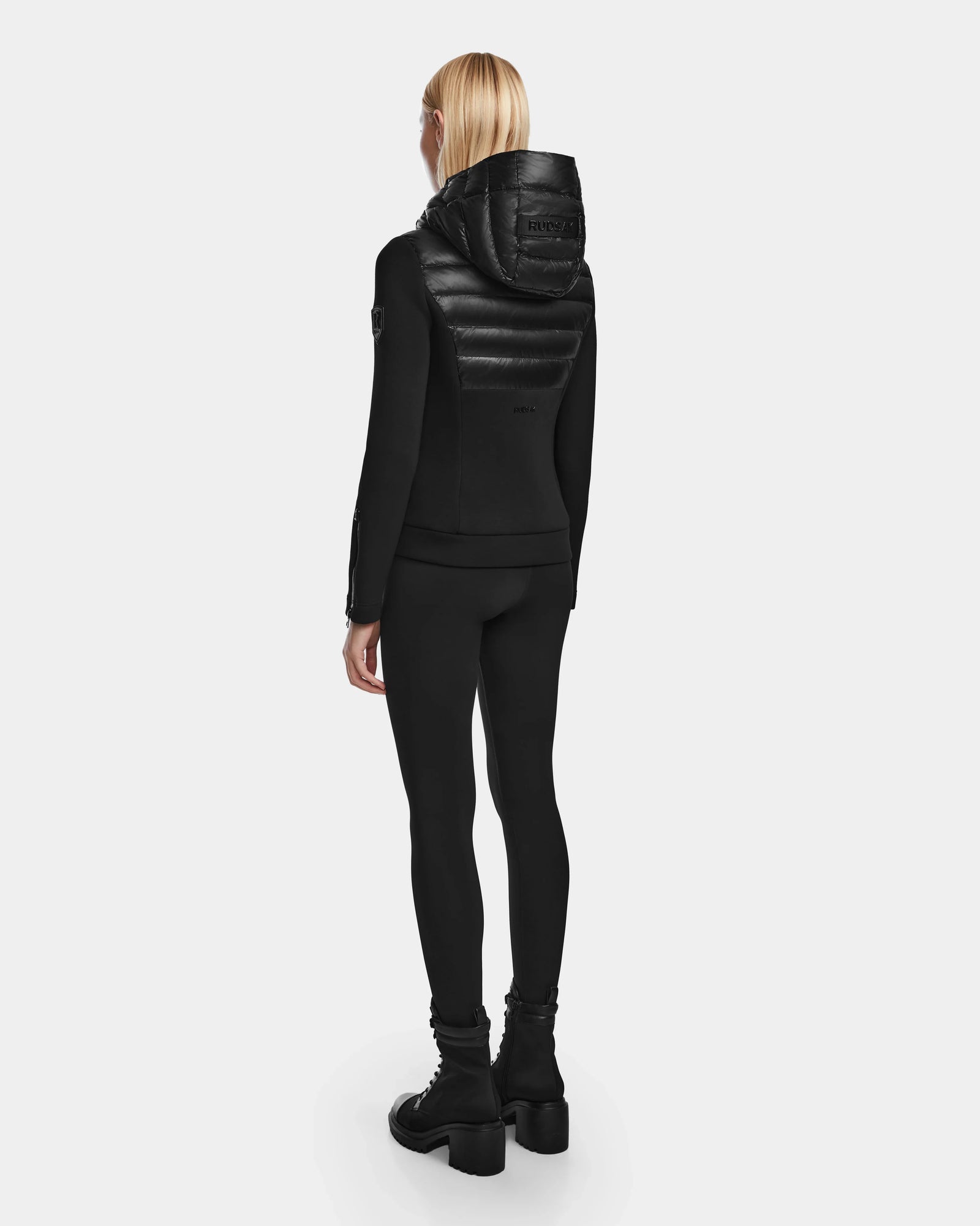 A woman wearing the RUDSAK MABS - 8122020 BLACK puffer jacket, crafted with RDS-certified down.