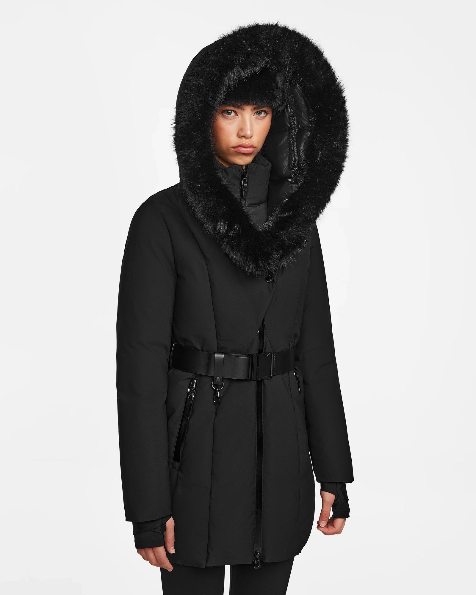 A person models the Rudsak MODA M - 8124555 Black winter coat, featuring a belted design and a large fur-trimmed hood, against a plain white background.