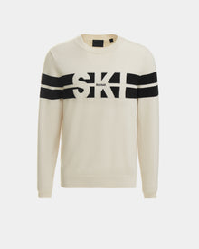 The OMAR - 6523507 Iceland by Rudsak is a cream crewneck sweater featuring black horizontal stripes, bold SKI lettering on the front, and subtle RUDSAK text below—ideal as an après-ski layer.
