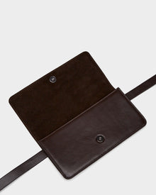 The PREYA - 8324508 Espresso by Rudsak is a dark brown leather belt bag with a suede interior, snap button closure, and a leather strap on each side.
