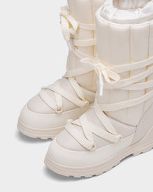 Close-up of the RODIN - 8224502 Iceland women’s winter boots by Rudsak, featuring off-white padded uppers, thick anti-slip soles, crisscross laces with “RUDSAK” branding, polar fleece lining for warmth, and a textured rubber sole for traction.